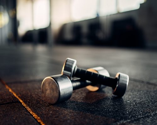 dumbbells-on-rubber-floor-closeup-fitness-club-PHAYDKU