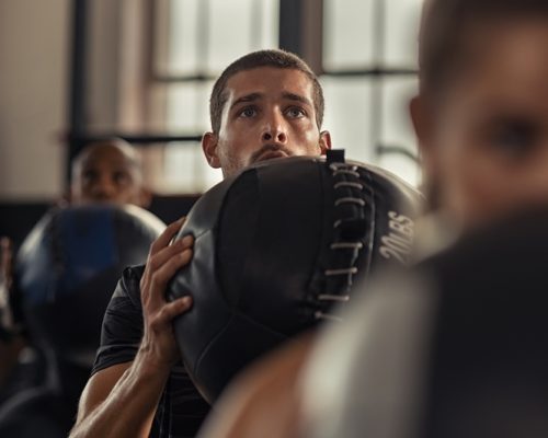 fitness-man-doing-squat-with-heavy-ball-YBQ9P4C